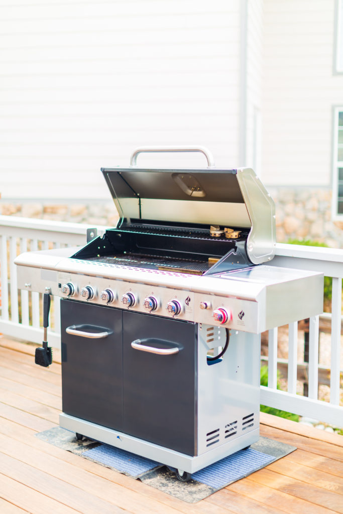 An outdoor grill with an open lid.
