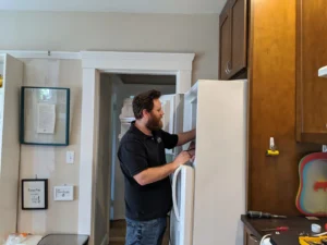 Technician inspecting open refrigerator