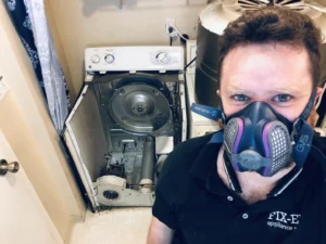 Technician servicing disassembled dryer