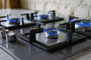 A gas stove top with blue flames.