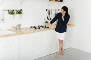 A woman on the phone with a technician as she tries to get her gas cooktop to ignite