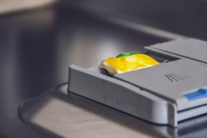 dishwasher detergent pod in the dispenser compartment of the dishwasher door