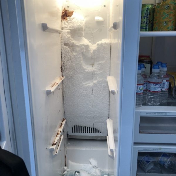 A frozen freezer inside a refrigerator.