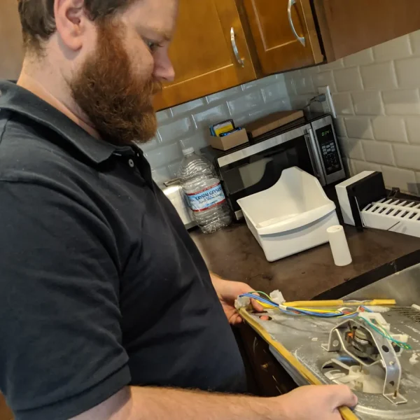 Technician inspecting refrigerator fan