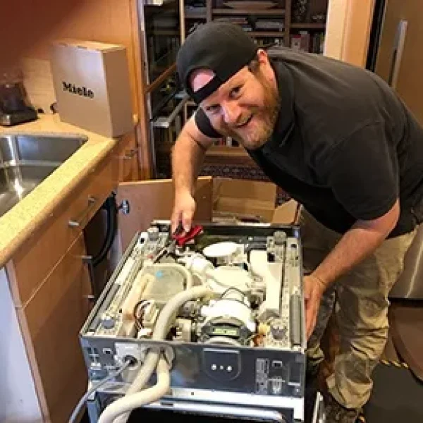 Technician repairing Miele dishwasher